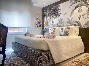 una camera da letto con un grande letto con lenzuola bianche di Hermitage Suites a Sassari