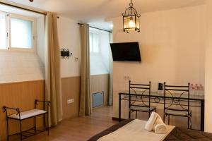 Hotel Alquimia Cadiz في كاديز: غرفة بطاولة وكراسي وتلفزيون