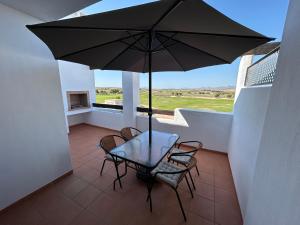 a patio with a table and chairs and an umbrella at New Penthouse with a fantastic view in Murcia