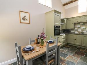 a kitchen with a wooden table and chairs at Graig Fawr in Builth Wells
