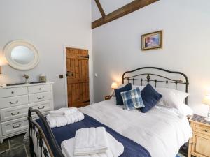 a bedroom with a bed and a dresser and a mirror at Graig Fawr in Builth Wells