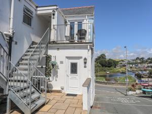 a white house with stairs leading up to the front door at Harbour View in Abersoch