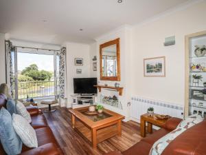 a living room with a couch and a tv at Harbour View in Abersoch
