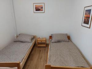a room with two beds and a night stand at Jagodzianka in Miłki