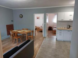 a kitchen and a dining room with a table and chairs at Jagodzianka in Miłki