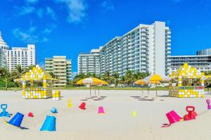 uma praia com cadeiras coloridas e guarda-sóis na areia em San Juan Hotel Miami Beach em Miami Beach