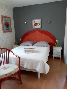 um quarto com uma cama grande e uma cadeira em 2 Chambres avec piscine et spa au calme, mer à proximité. em Portiragnes