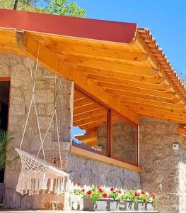 awning over a porch of a house with flowers at Casa da Quinta Costa D'Além Gerês in Terras de Bouro