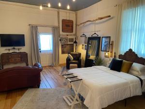 1 dormitorio con 1 cama grande y sala de estar en Painted Lady Bed & Brew en Albuquerque