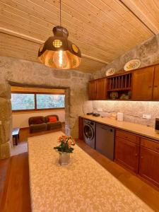 eine Küche mit einem Tisch mit einer Vase mit Blumen darauf in der Unterkunft Casa da Quinta Costa D'Além Gerês in Terras de Bouro + 55 Fotos