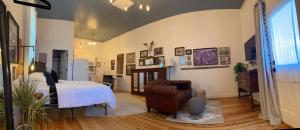 a bedroom with a bed and a chair in a room at Painted Lady Bed & Brew in Albuquerque