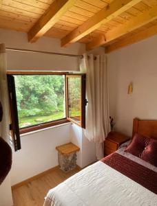 a bedroom with a bed and a large window at Casa da Quinta Costa D'Além Gerês in Terras de Bouro