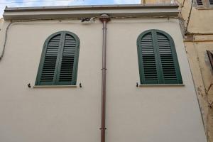two windows with green shutters on a building at Grand Suite King Of Majorca Esclusiva su due livelli in Alghero