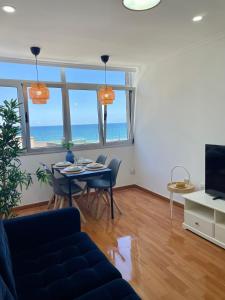 a living room with a table and chairs and the ocean at Las Canteras View Home in Las Palmas de Gran Canaria