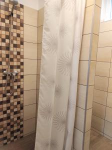 a shower curtain in a bathroom next to a shower at Balogh Vendégház in Sárospatak