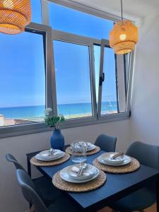 una sala da pranzo con tavolo e vista sulla spiaggia di Las Canteras View Home a Las Palmas de Gran Canaria