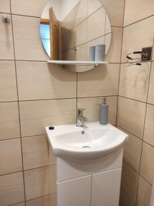 y baño con lavabo blanco y espejo. en Balogh Vendégház, en Sárospatak