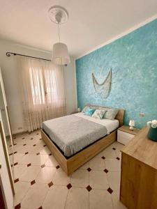 a bedroom with a bed and a blue wall at Nonna Sere Home in Riva Ligure