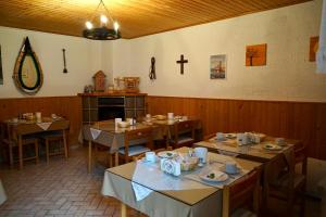 a dining room with tables and a cross on the wall at Privatzimmer Haider in Illmitz