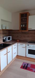a kitchen with white cabinets and white appliances at Appartement Gertraud in Hieflau