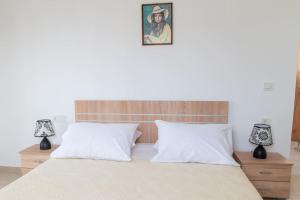 una camera da letto con un grande letto bianco con due lampade di Zografia - Charming House near the coast a Città di Kos