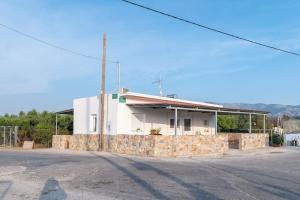 a building with a stone wall next to a street at Zografia - Charming House near the coast in Kos Town