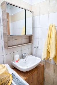 ein Bad mit einem Waschbecken und einem Spiegel in der Unterkunft Zografia - Charming House near the coast in Kos-Stadt