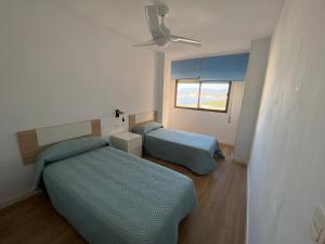 ein Schlafzimmer mit zwei Betten und einem Deckenventilator in der Unterkunft Torrenueva con vistas al mar in Torrenueva + 24 Fotos