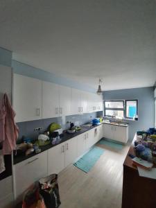 uma grande cozinha com armários brancos e uma janela em Enjoy the Island - Rua do Negrão em Ponta Delgada