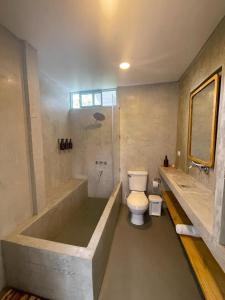 uma casa de banho com uma banheira, um WC e um chuveiro em La Posada Circa em Montenegro