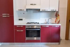 a kitchen with red cabinets and a sink at SE010 - Senigallia, bilocale sul mare con spiaggia in Senigallia