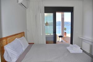 sypialnia z łóżkiem i widokiem na ocean w obiekcie Villa Tulivu w mieście Paleros