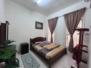 1 dormitorio con cama y ventana en Perdana Cottage, Peaceful & Cozy Residential Area en Sungai Petani