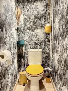 a bathroom with a toilet with a yellow lid at Le Cachot des Rois in Dourdan