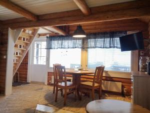 a dining room with a table and chairs and a window at Kallioranta in Lestijärvi +13 photos