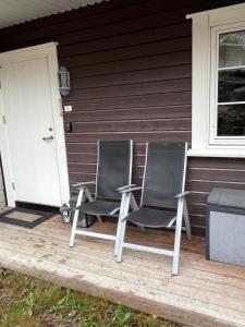 two chairs sitting on the front porch of a house at Leilighet på Gautefall in Drangedal