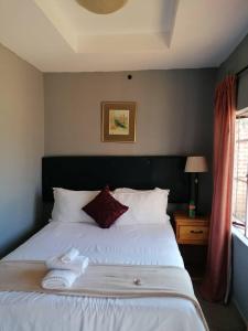 um quarto com uma cama branca e toalhas em dunduzu village lodge em Mzuzu