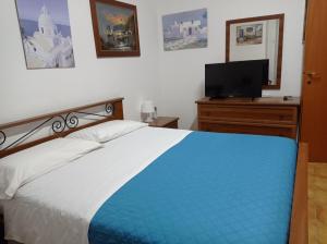 a bedroom with a bed and a tv on a dresser at Villa Angela in Marinella di Selinunte +9 photos