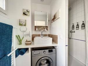 uma casa de banho com um lavatório e uma máquina de lavar roupa em Le Cachot des Rois em Dourdan