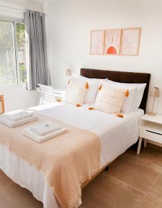 um quarto com uma grande cama branca com almofadas brancas em Local 102 Apartment no Rio de Janeiro