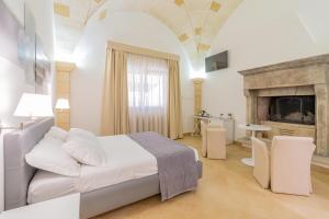 - une chambre blanche avec un lit et une cheminée dans l'établissement La Botte, à Giurdignano