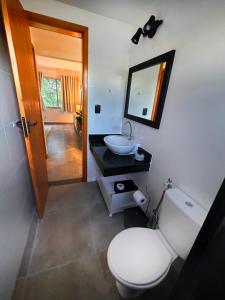 uma casa de banho com um WC, um lavatório e um espelho. em Local 102 Apartment no Rio de Janeiro