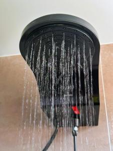 um chuveiro com água a sair dele em Local 102 Apartment no Rio de Janeiro
