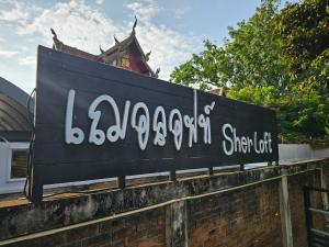 een bord bovenop een stenen muur bij Sherloft Home & Hostel in Chiang Mai