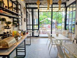 a large room with tables and chairs and windows at Sherloft Home & Hostel in Chiang Mai +32 photos