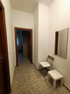 um quarto com uma cadeira, uma mesa e um corredor em Appartamento luminoso in zona centrale em Montesilvano