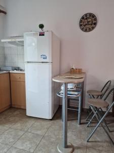 RizáにあるLemi Apartmentsのキッチン(白い冷蔵庫、テーブル付)