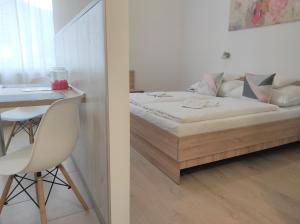 1 dormitorio con 1 cama y 1 mesa con silla en Balogh Vendégház en Sárospatak