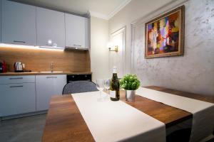 a kitchen with a table with a bottle of wine at Odrys Apartments in Plovdiv
