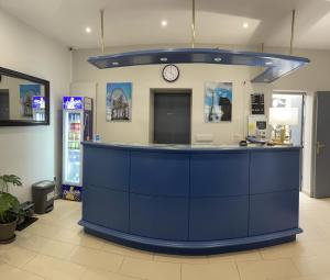 a blue counter in a pharmacy with a clock at Hipotel Lilas Gambetta in Paris